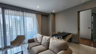Spacious modern living room with large windows and elegant furnishings in a high-rise apartment.