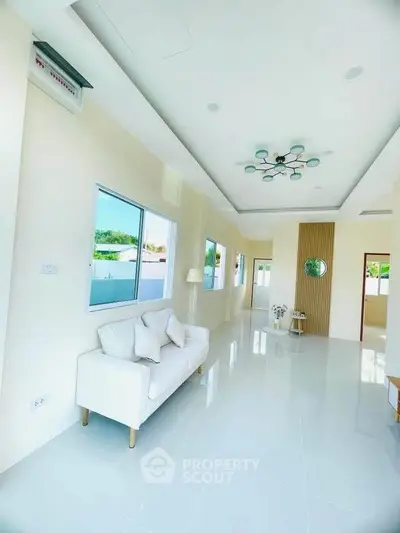 Spacious modern living room with elegant lighting and large windows for natural light.