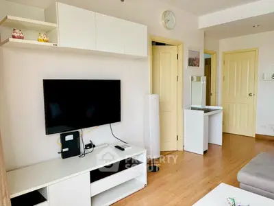 Modern living room with sleek TV setup and stylish decor in a cozy apartment.