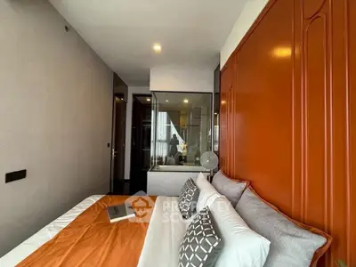 Modern bedroom with stylish orange accent wall and cozy bedding