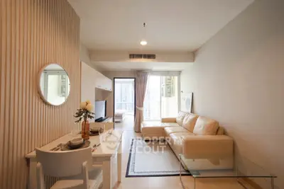 Modern living room with beige leather sofa and stylish decor in a high-rise apartment.