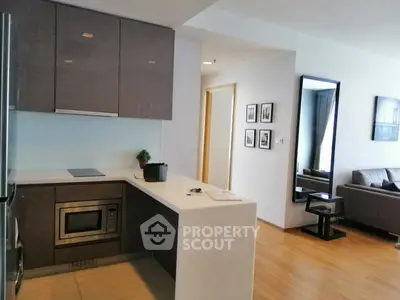 Modern open-layout kitchen with sleek cabinetry and integrated appliances in a stylish apartment.