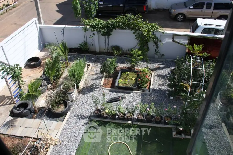 Charming garden view with lush greenery and decorative pond in residential backyard.