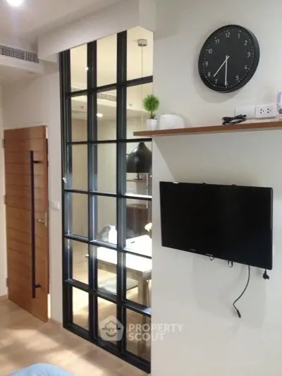 Modern living room with wall-mounted TV and stylish glass partition