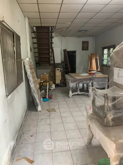 Spacious room with staircase and tiled floor, ideal for renovation projects.