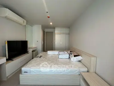 Modern bedroom with sleek design, featuring a comfortable bed, built-in wardrobe, and air conditioning.