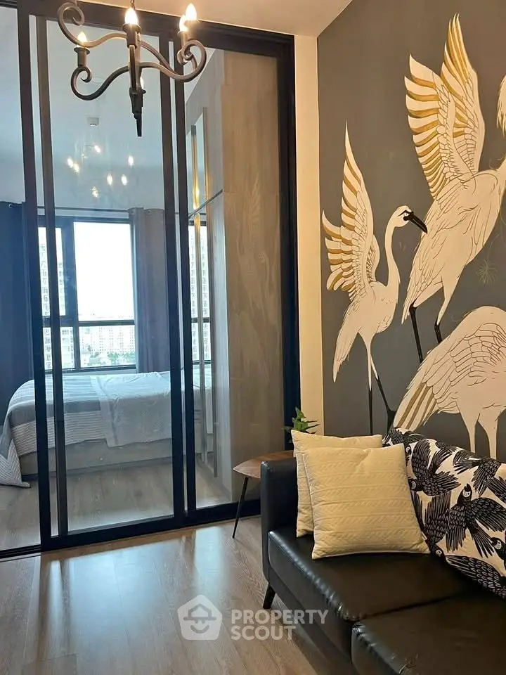 Stylish living room with elegant decor and glass partition leading to a cozy bedroom.