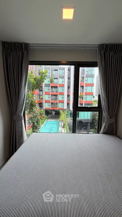 Modern bedroom with pool view in vibrant urban apartment complex