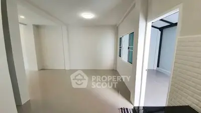 Spacious empty room with large windows and modern lighting, perfect for customization.