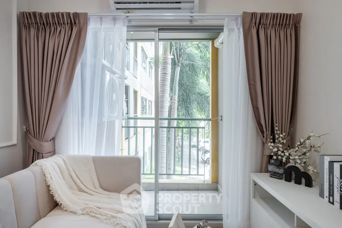 Cozy living room with balcony view, elegant curtains, and stylish decor