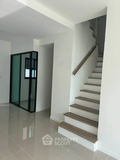 Modern minimalist interior with sleek staircase and glossy tiled flooring