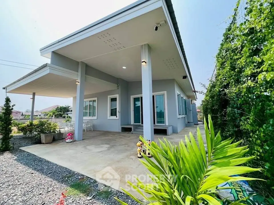 Modern single-story home with spacious patio and lush greenery, perfect for family living.