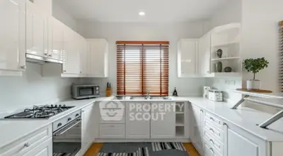 Modern kitchen with sleek white cabinetry and gas stove, perfect for culinary enthusiasts.
