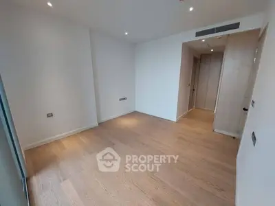 Spacious empty bedroom with wooden flooring and built-in wardrobe