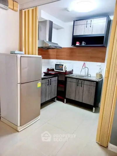 Modern kitchen with sleek cabinets and stainless steel appliances in a cozy apartment.
