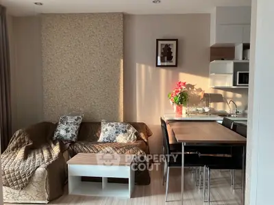 Cozy living room with modern kitchen, stylish decor, and natural light.