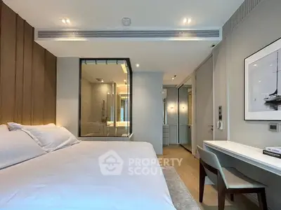Luxurious modern bedroom with elegant decor and glass-walled ensuite bathroom, perfect for sophisticated living.