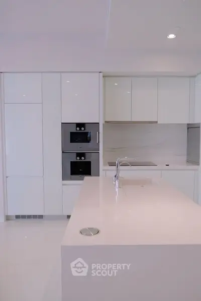 Sleek modern kitchen with white cabinetry and built-in appliances, perfect for contemporary living.