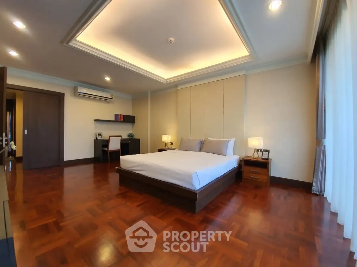 Spacious bedroom with elegant wooden flooring and modern decor
