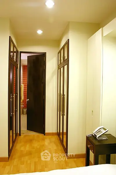 Spacious walk-in closet with elegant wooden flooring and ample storage space.