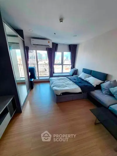 Modern bedroom with city view, featuring a cozy bed and stylish decor in a high-rise apartment.