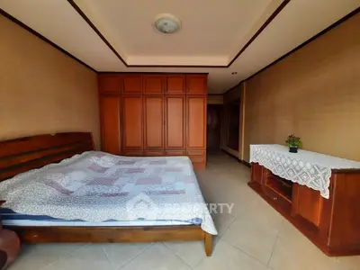 Spacious bedroom with wooden furniture and ample storage space