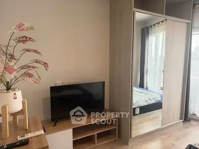 Modern bedroom with mirrored wardrobe and TV stand, featuring a cozy bed and stylish decor.