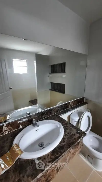 Modern bathroom with marble countertop and large mirror