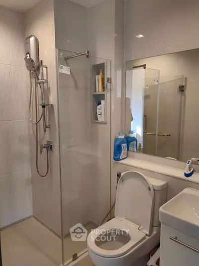 Modern bathroom with glass shower and sleek fixtures in a contemporary home.