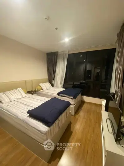 Modern twin bedroom with large window and stylish decor