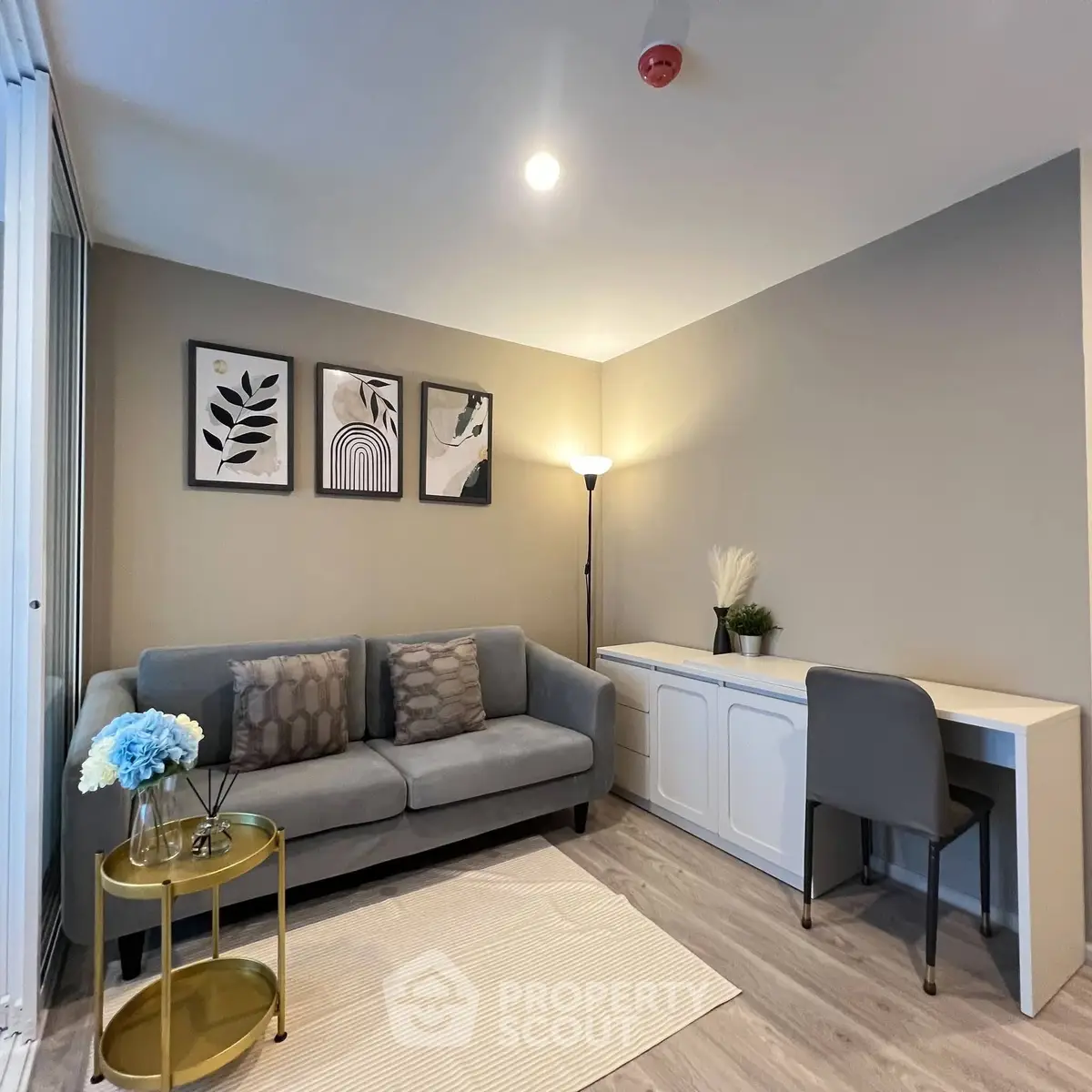Modern living room with stylish decor, cozy sofa, and elegant workspace in a contemporary apartment.