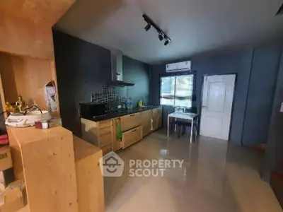 Spacious kitchen with modern appliances, ample counter space, and sleek cabinetry, complemented by large windows for natural light.