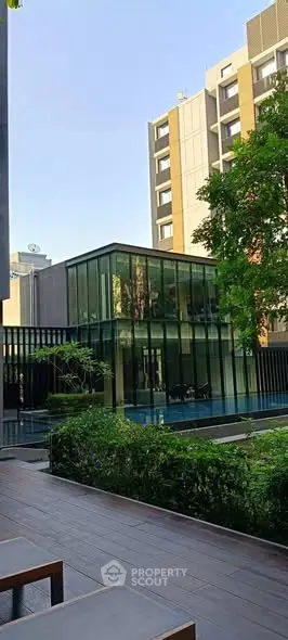Modern building exterior with glass facade and lush greenery