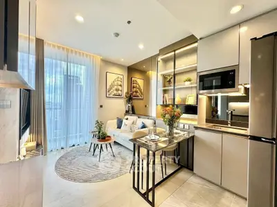 Modern open-layout kitchen and living room with stylish decor and natural light.
