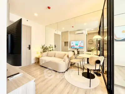 Modern living room with stylish decor and open layout, featuring a cozy sofa and dining area.