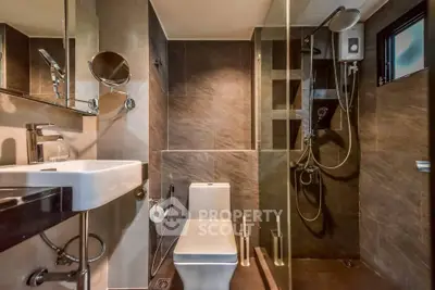 Modern bathroom with sleek design, featuring a glass shower enclosure and contemporary fixtures.
