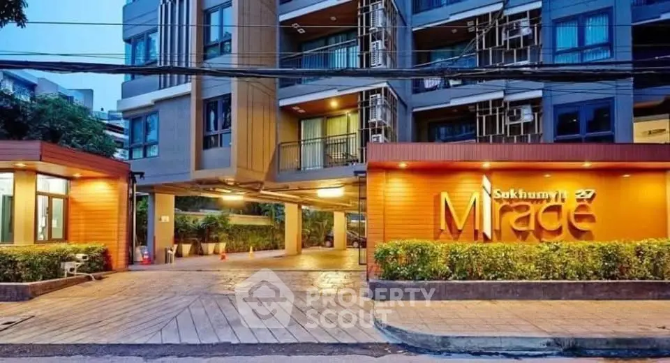 Modern condominium entrance with stylish facade and lush greenery at Sukhumvit 27.