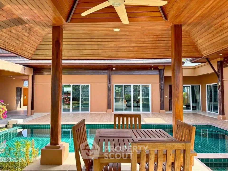Luxurious outdoor pool area with wooden deck and stylish furniture, perfect for relaxation and entertainment.