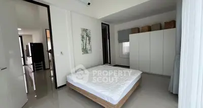 Spacious modern bedroom with minimalist decor and large wardrobe