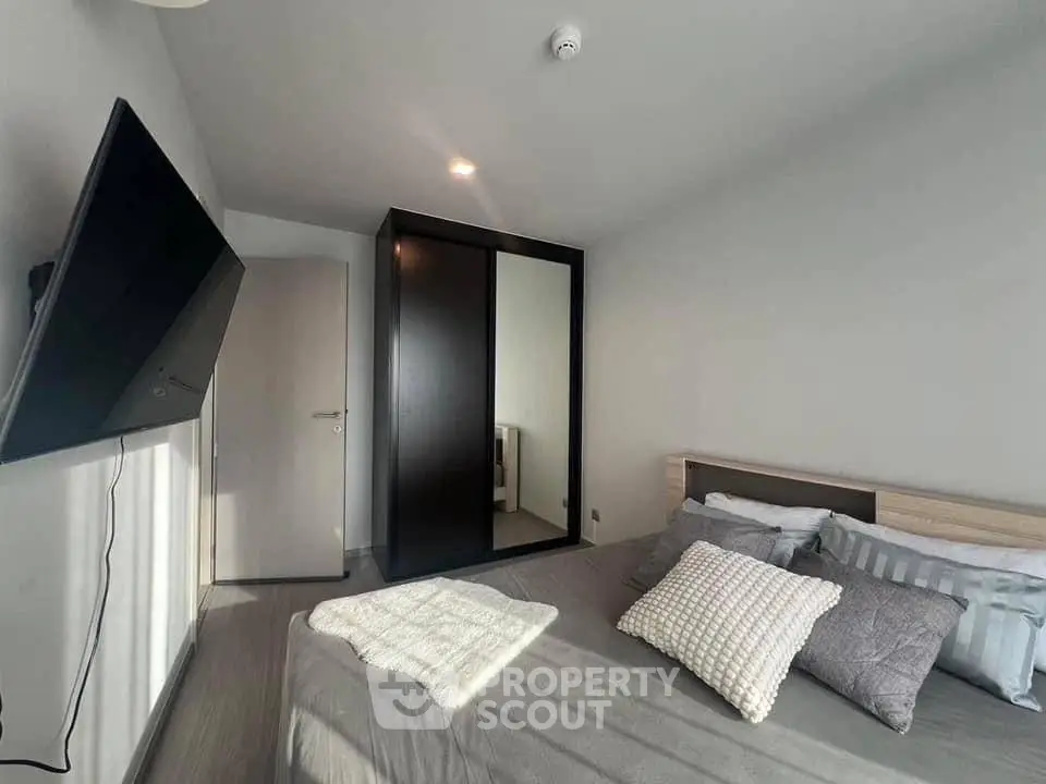 Modern bedroom with sleek design and wall-mounted TV, perfect for relaxation.
