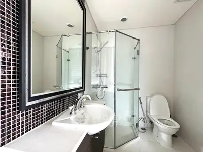 Modern bathroom with glass shower and sleek fixtures in contemporary home.
