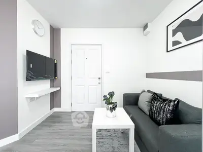 Modern living room with sleek decor and wall-mounted TV, featuring a stylish gray sofa and minimalist design.