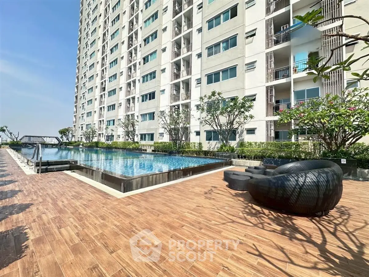 Luxurious apartment building with stunning poolside area and modern outdoor seating.