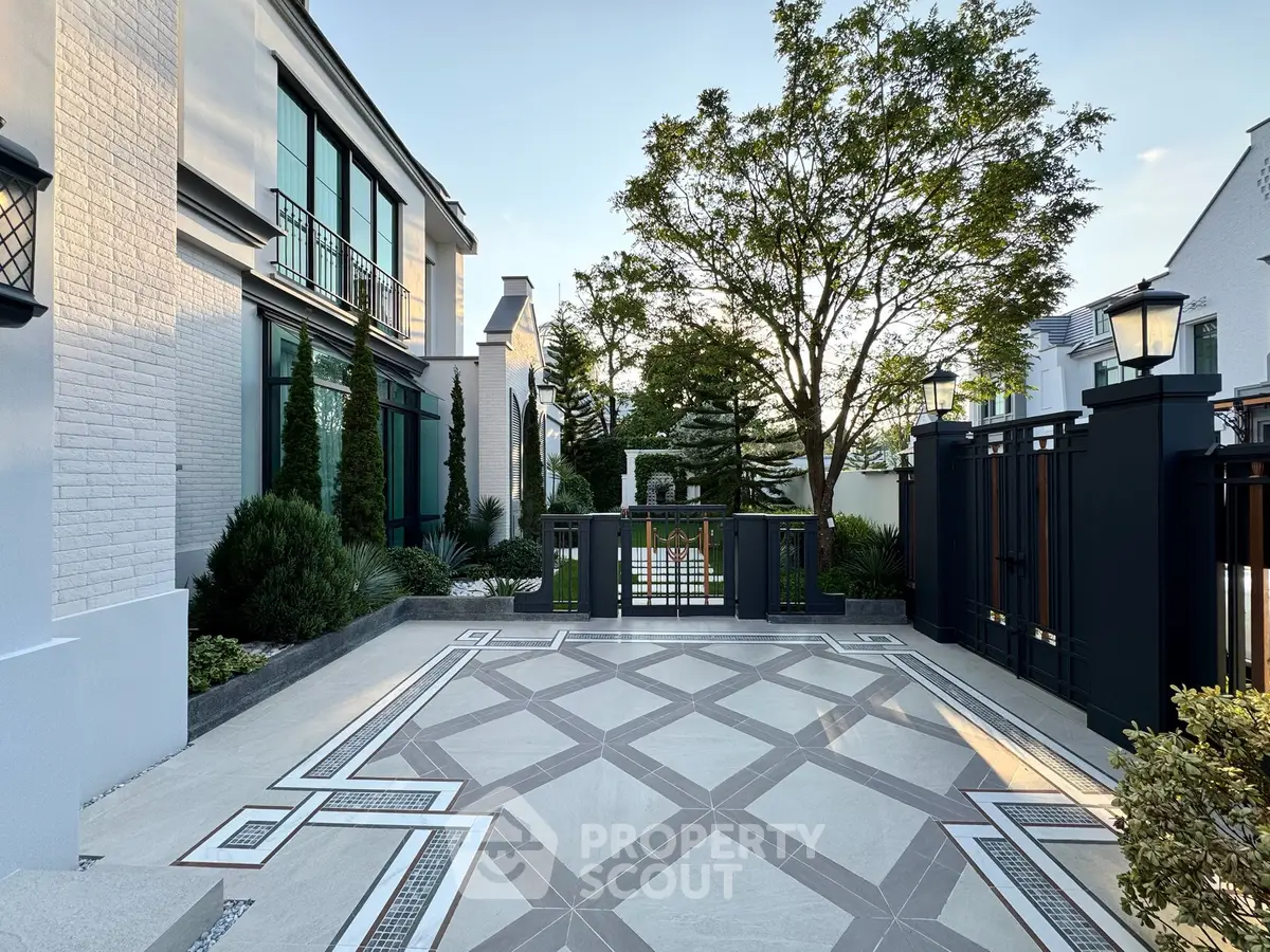 Elegant modern building exterior with stylish gate and lush landscaping
