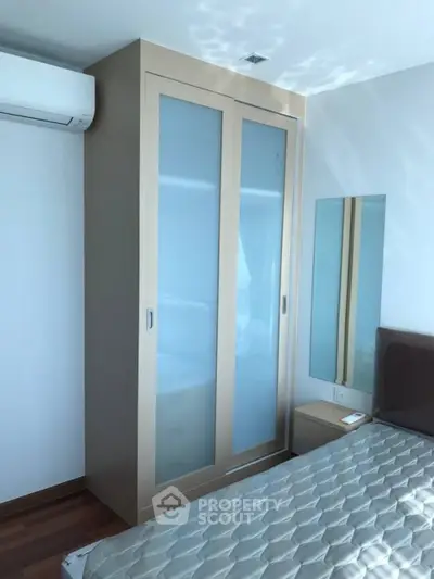 Modern bedroom with sleek wardrobe and air conditioning, perfect for comfortable living.