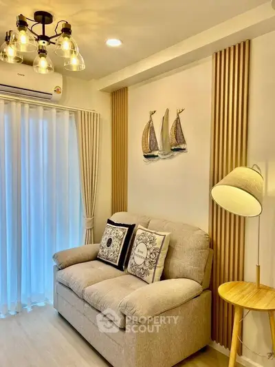 Cozy living room with stylish decor and natural light, featuring a comfortable sofa and elegant lighting.