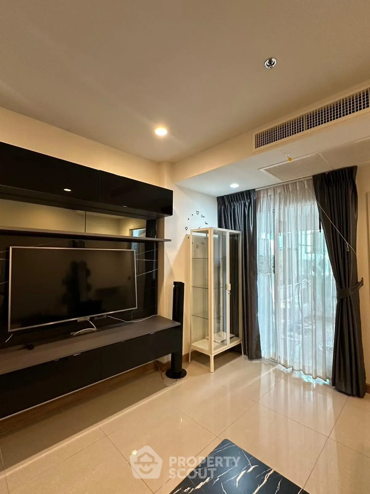 Modern living room with sleek TV unit and floor-to-ceiling windows