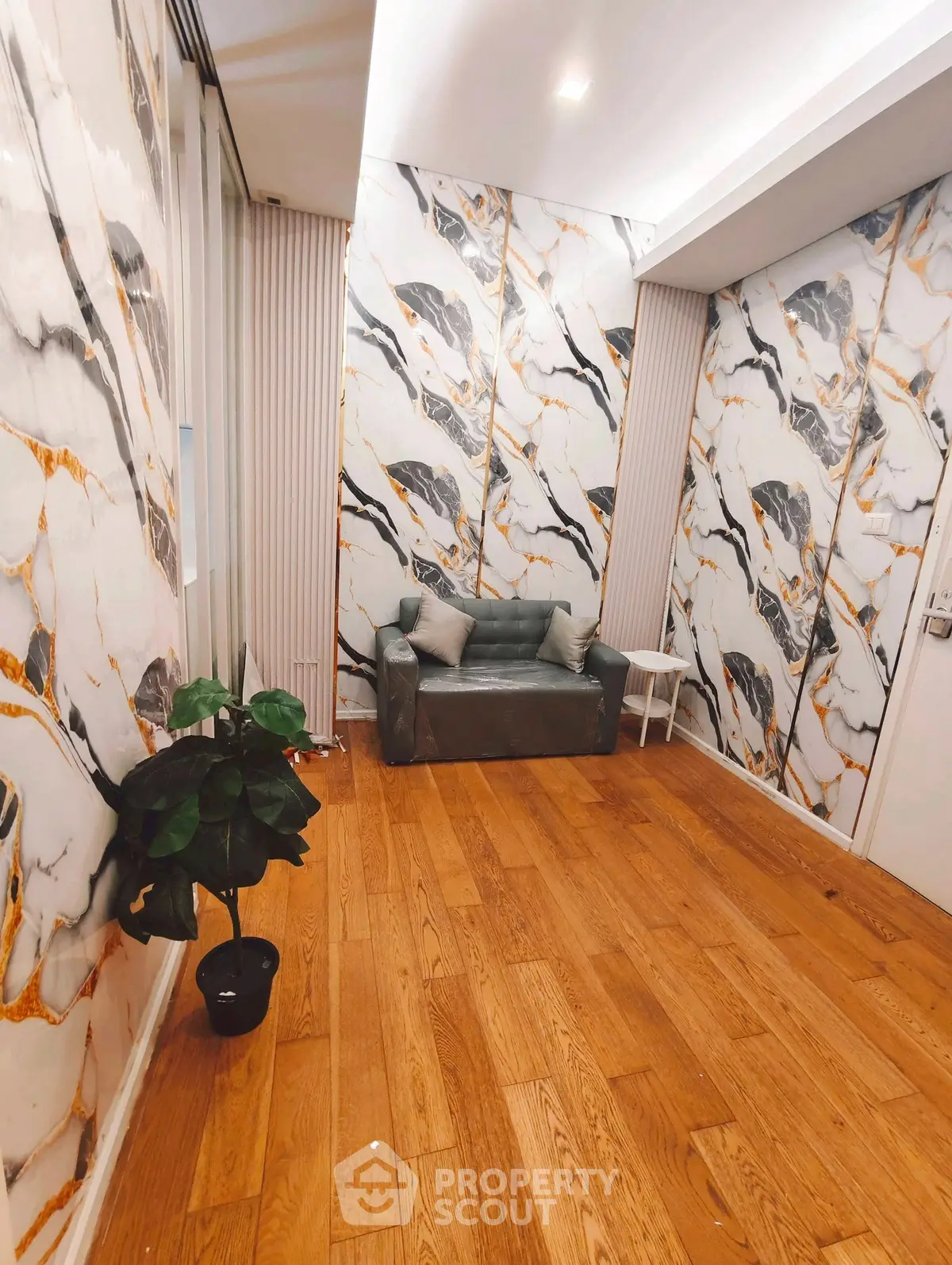 Stylish interior with marble-patterned walls and cozy seating area, perfect for modern living.