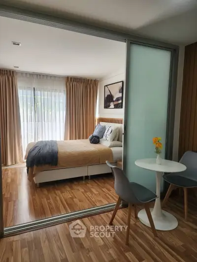 Modern bedroom with sliding glass doors and cozy decor in a stylish apartment.