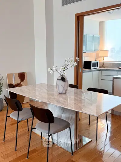 Modern dining area with marble table and open kitchen in luxury apartment